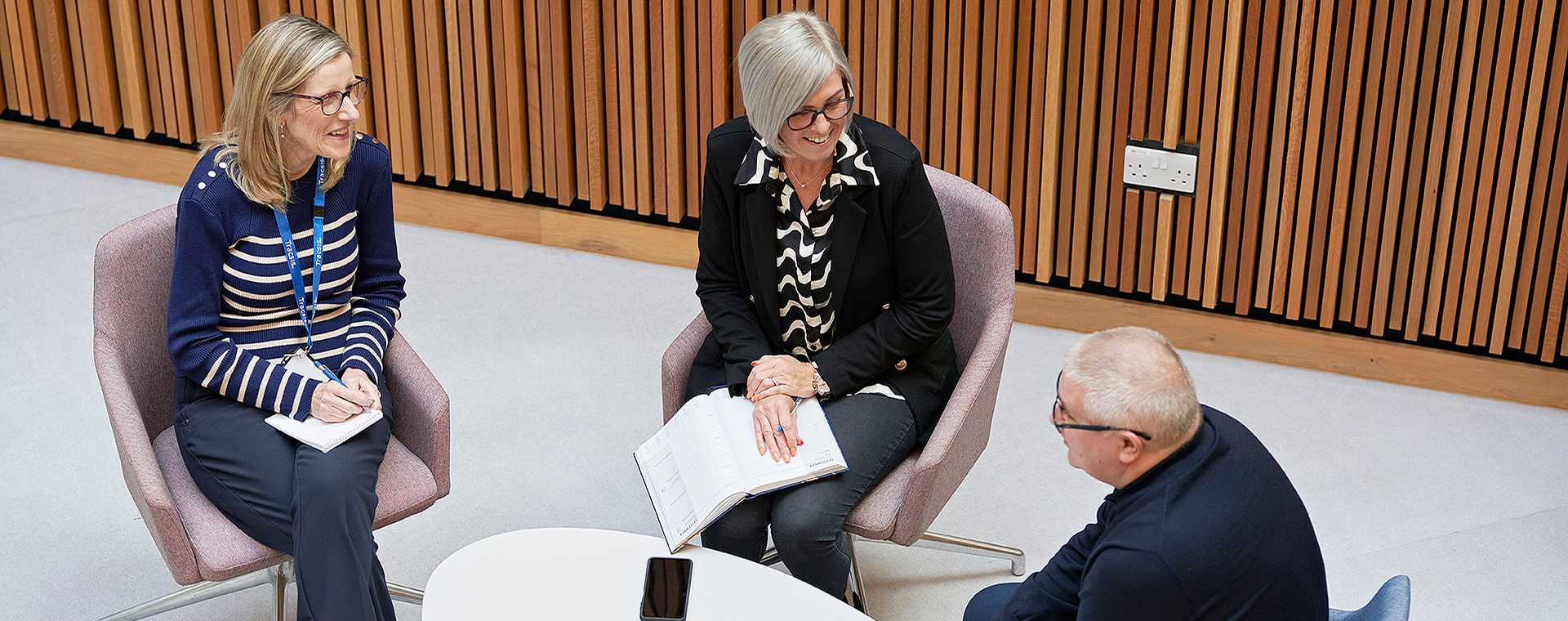 People talking around a desk.